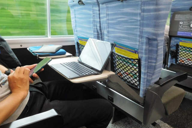電車でパソコンを開いて作業する男性